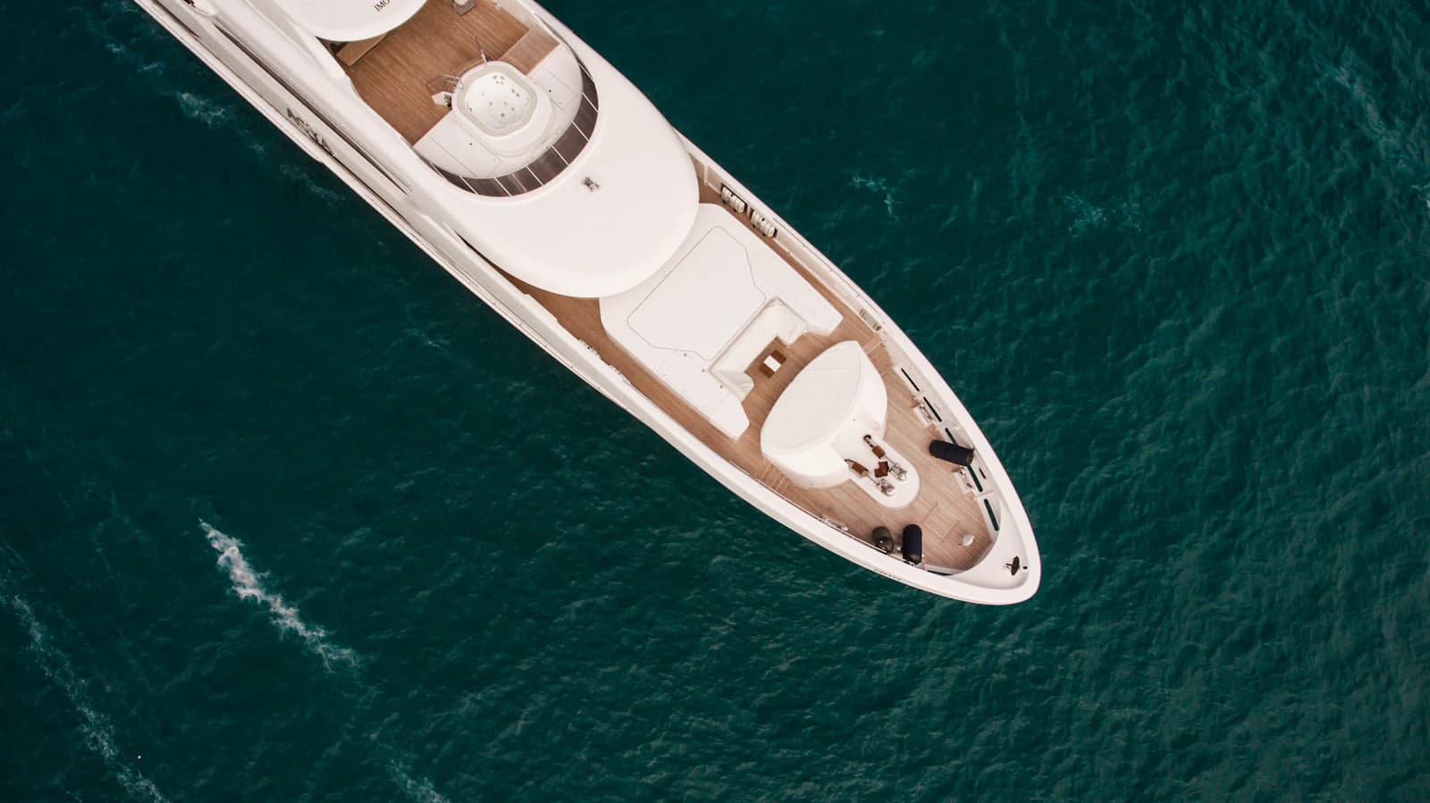 Aerial view of a white motor yacht on turquoise water